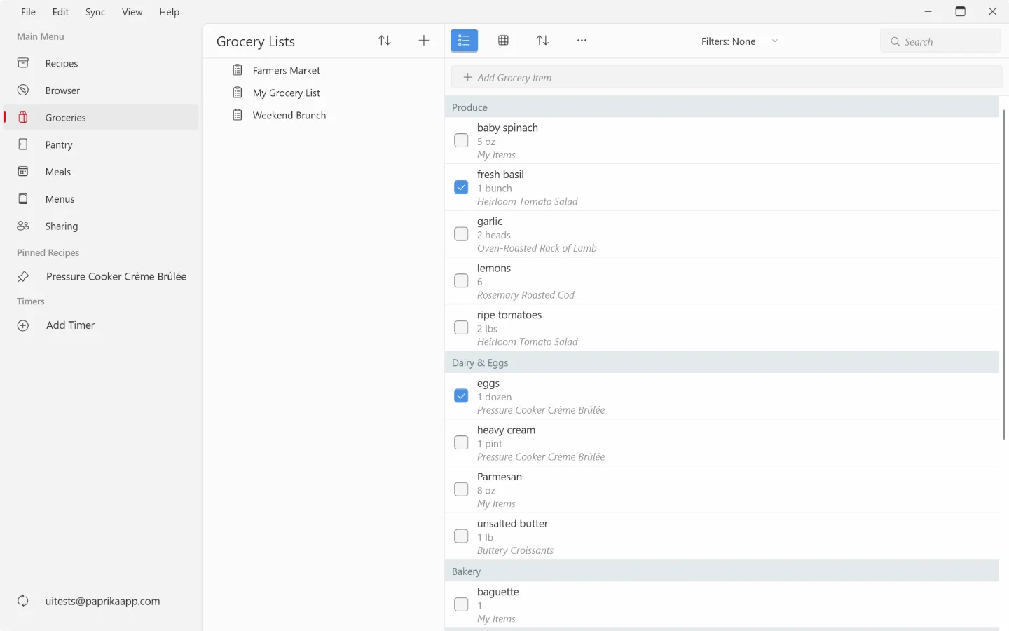 The Groceries screen on Windows: grocery lists in the middle column, the list sorted by aisle on the right with two items checked off, and the add grocery item field, sort, actions, filters and search above it.