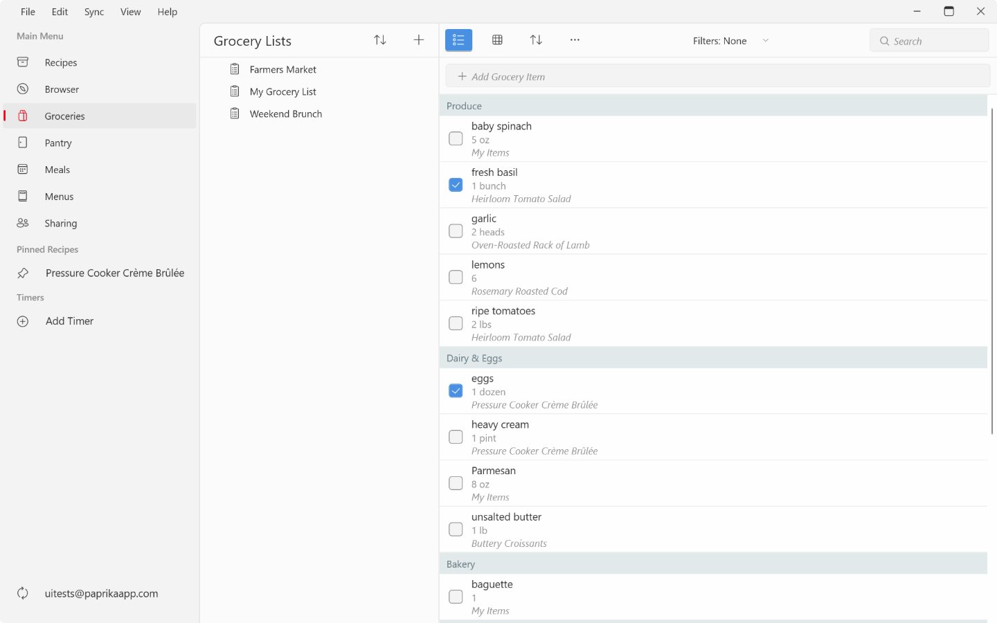 The Groceries screen on Windows: grocery lists in the middle column, the list sorted by aisle on the right with two items checked off, and the add grocery item field, sort, actions, filters and search above it.